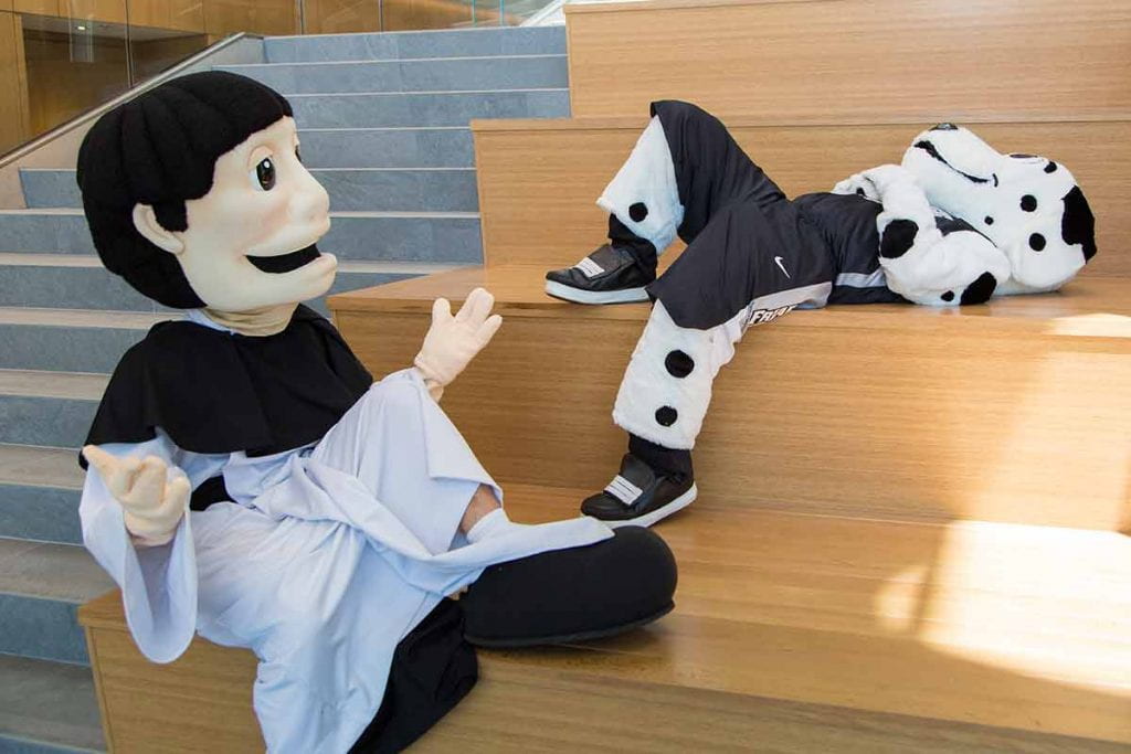 Two Mascots (Huxley and Friar Dom) sitting and talking in the Student Center