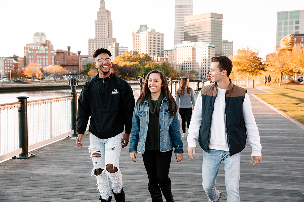 Students walking on bridge with Providence skyline in the background