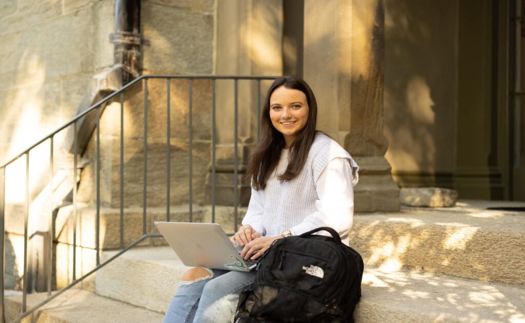 Student sitting on steps with laptop
