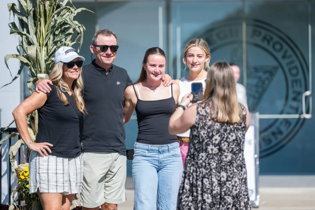 family taking a photo at homecoming
